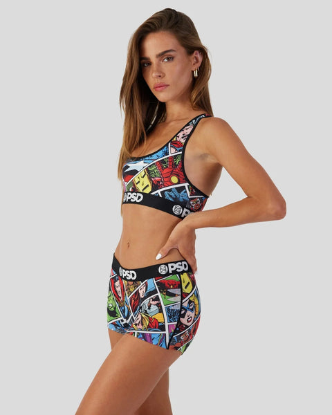 Woman wearing Marvel comic-print sports bra and shorts set with colorful graphic panels and black waistbands.