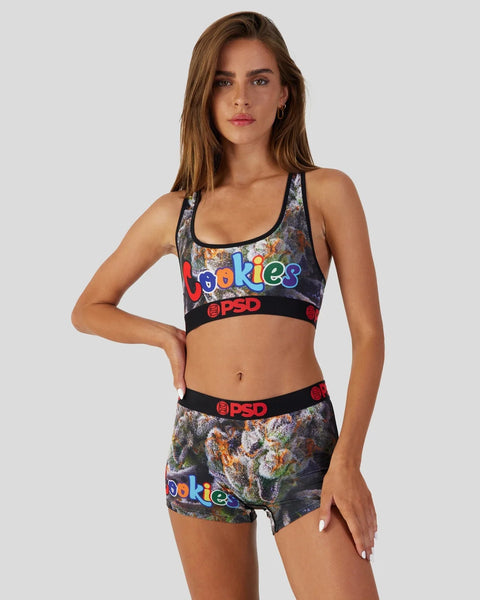 Woman wearing colorful Cookies and PSD branded sports bra and shorts set with flower and text print design.
