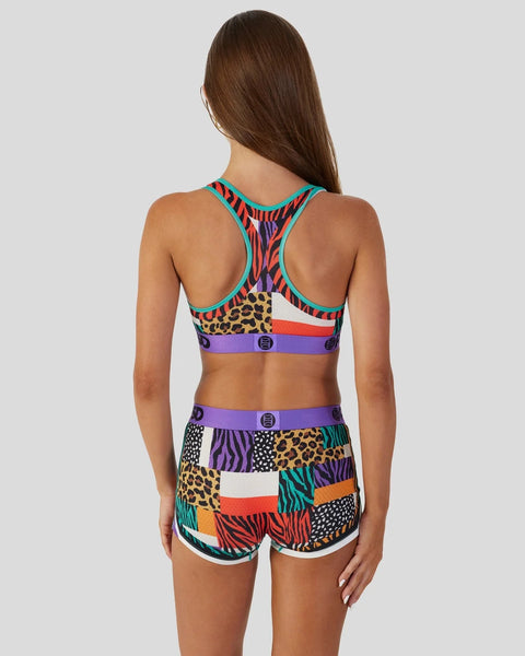 Women's sports bra and shorts set with multicolor animal print and geometric pattern blocking in turquoise, purple, red, and 