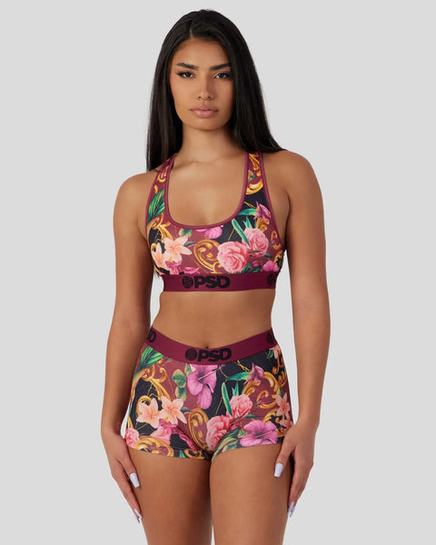 Plum-colored sports bra and shorts set with multicolored floral print and branded waistband.