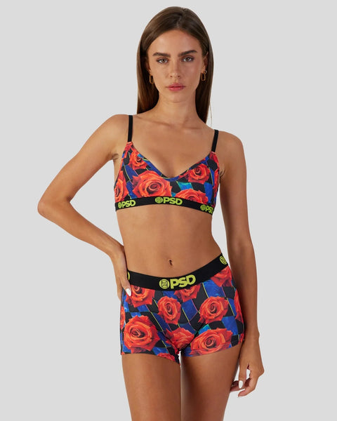 Red rose and blue floral print sports bra and shorts set with black straps and neon branding waistbands.