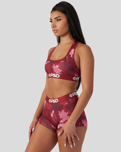 Woman wearing burgundy and pink camouflage sports bra and shorts set with PSD branding on the waistbands.