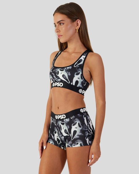 Woman wearing black and white ghost-print sports bra and matching shorts with PSD branding.