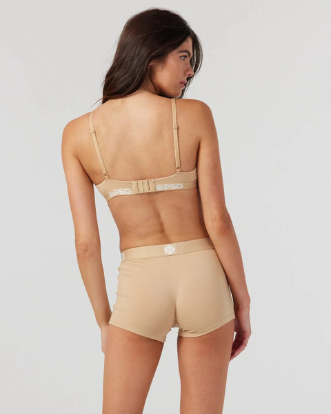 Woman wearing a sand-colored modal bra with adjustable straps and matching shorts, shown from back view.
