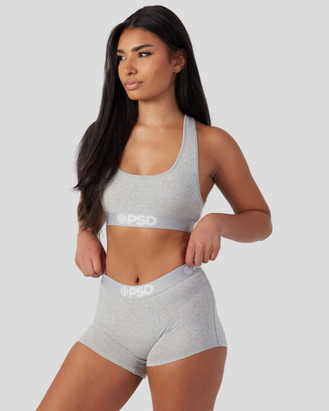 Athletic grey racerback sports bra with matching shorts, both featuring PSD branding on elastic bands.