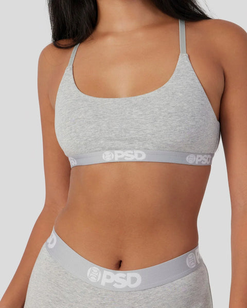 Grey athletic bra with scoop neckline, thin straps, and branded waistband on matching briefs.