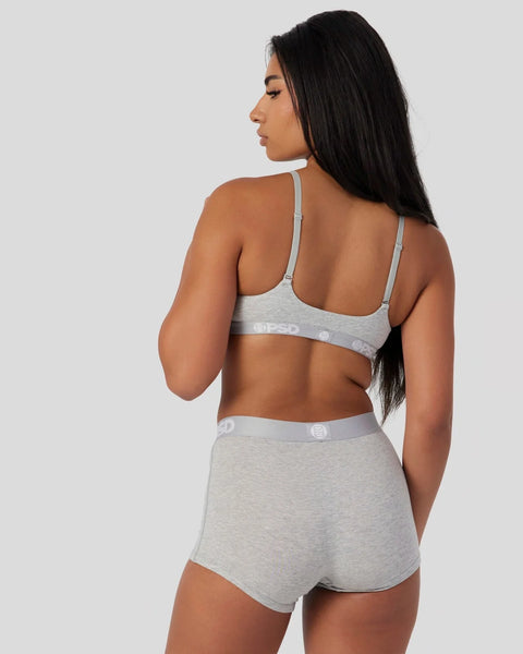 Woman wearing grey athletic grey bra and shorts set with branded waistband, shown from back view.