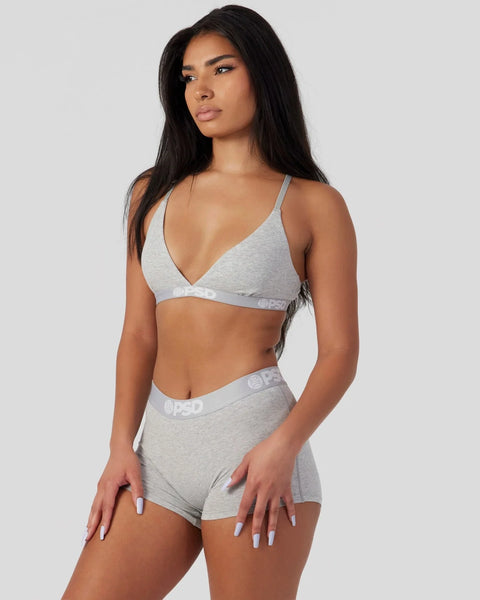 Woman wearing grey athletic grey triangle bra and shorts with branded waistband.