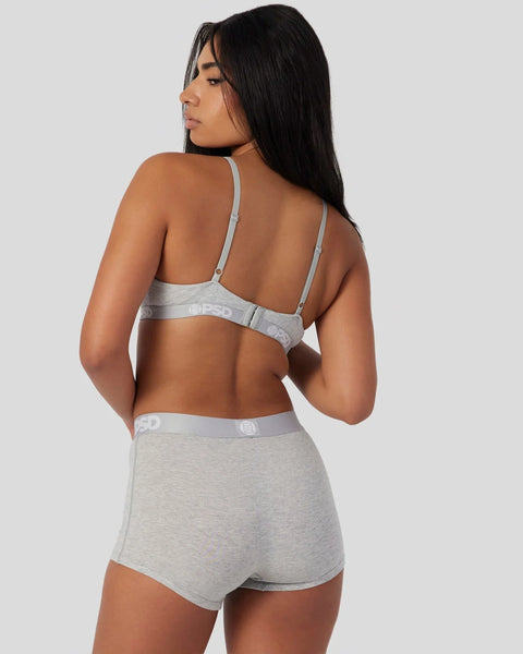 Woman wearing grey athletic grey bra and matching shorts with branded waistband, shown from back view.