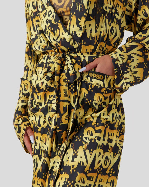 Black and gold graffiti-print jumpsuit with long sleeves, drawstring waist, and front pockets featuring PSD branding.