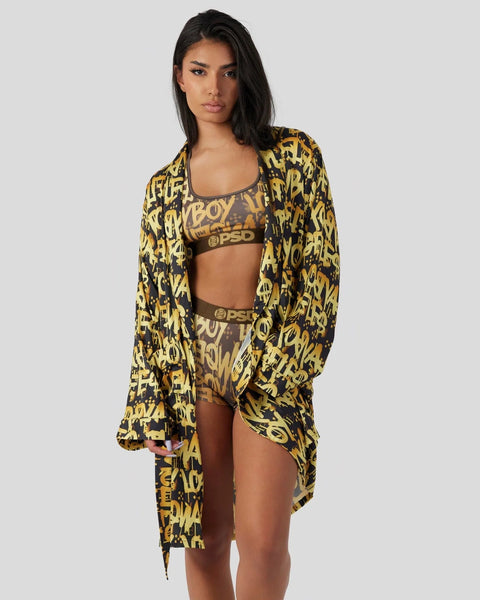 Woman wearing yellow and black graffiti-print cardigan, matching sports bra and shorts with logo branding.