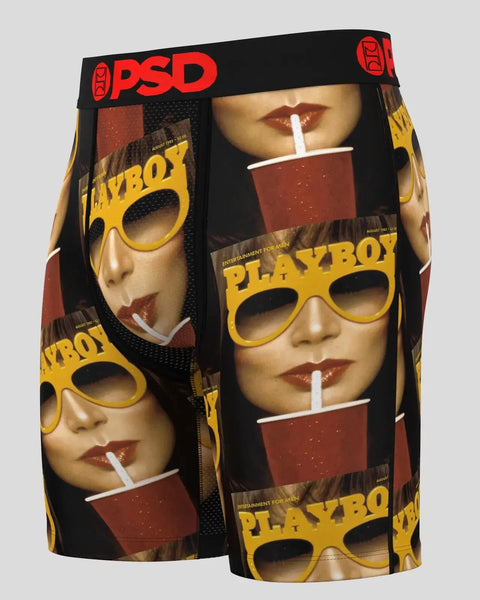 Black PSD boxer shorts with repeating Playboy magazine cover print featuring yellow sunglasses and red cups.