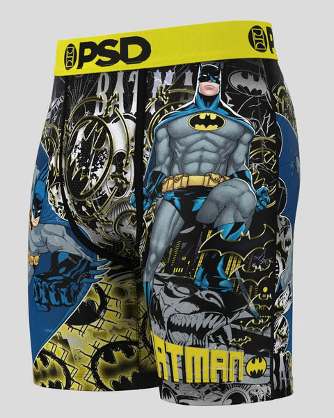 PSD brand boxer shorts with Batman character print in blue, black, and yellow, featuring yellow waistband with logo.