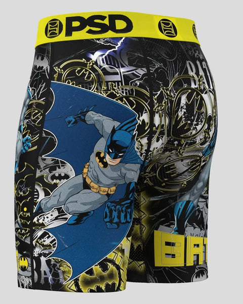 PSD brand boxer shorts with Batman character in blue costume and yellow belt against black background with bat logo patterns.