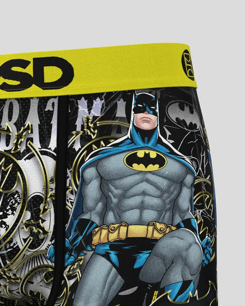 Batman character wearing blue and gray suit with yellow belt and bat logo, surrounded by decorative gold and black patterns o