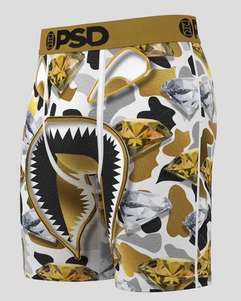 PSD brand compression shorts with gold and black shark mouth graphic print and geometric crystal design on white background.