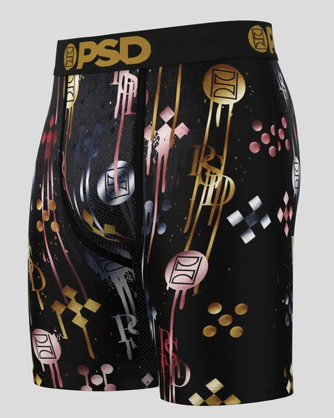 Black shorts with gold, pink, and white geometric and abstract pattern, PSD brand waistband.