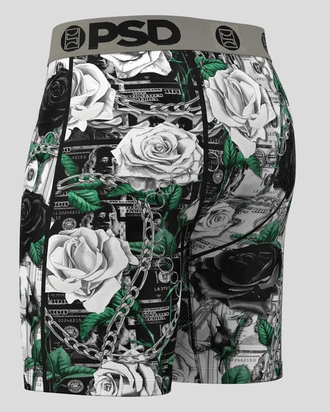 PSD men's shorts with black and white roses, green leaves, currency imagery, and chain pattern on black background.