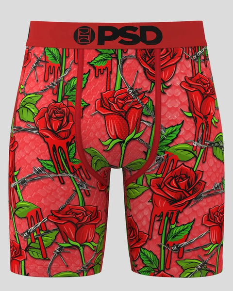 Red PSD boxer shorts with red roses, green leaves, and thorny vines on coral background.