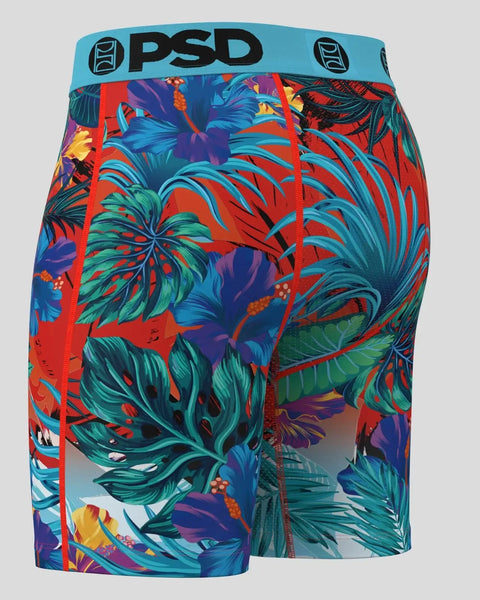 PSD boxer briefs with turquoise waistband and multicolored tropical leaf and flower print on red background.