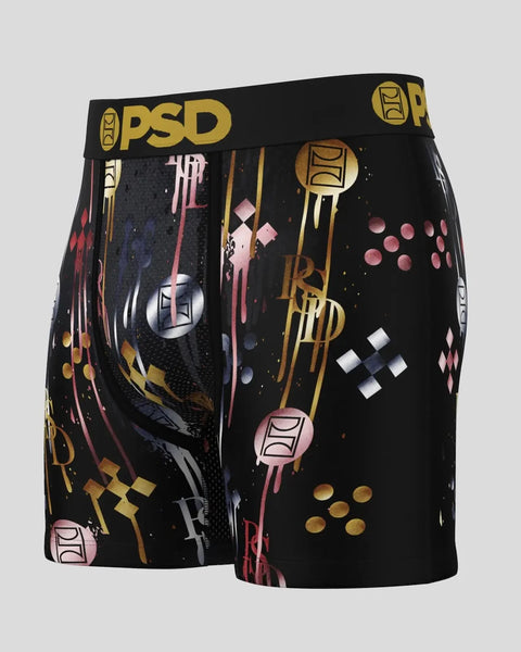 Black PSD boxer shorts with gold, pink, and white geometric and abstract graphic print throughout.