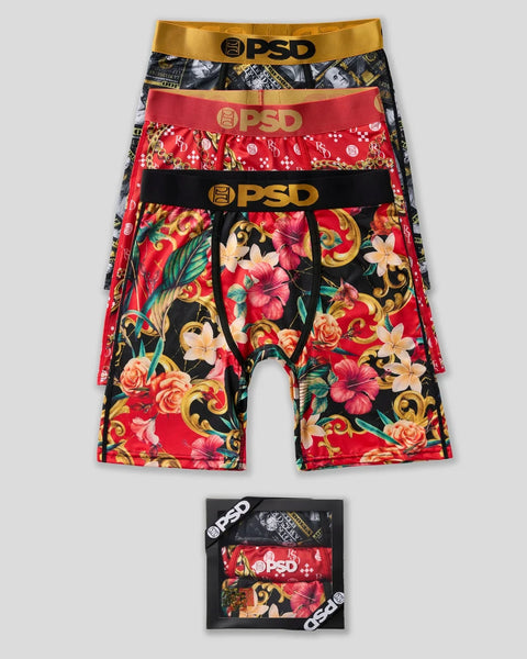 Three PSD boxer briefs with gold, red, and floral patterned designs, featuring gold and black waistbands with logo.