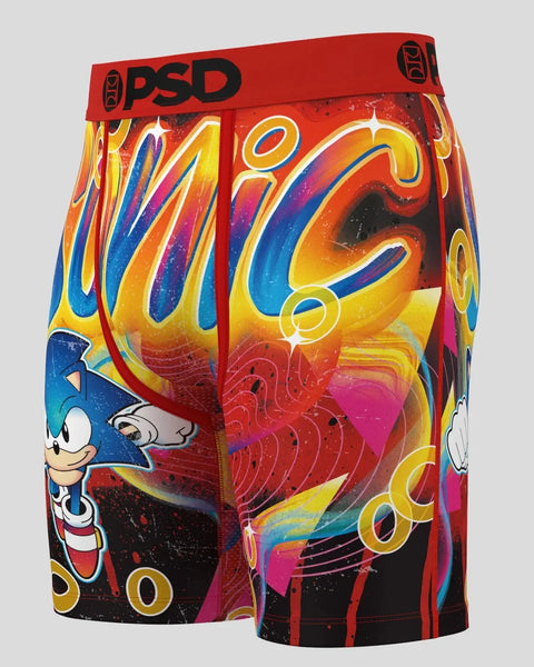 Red PSD boxer briefs with colorful swirling abstract design, Sonic character on left leg, and black waistband.