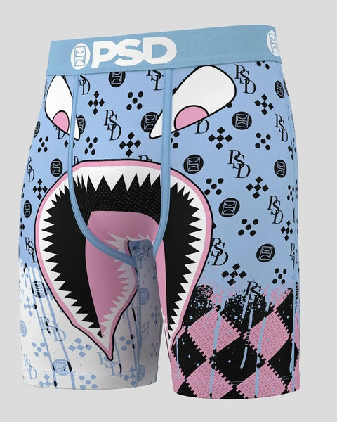 Blue PSD boxer shorts with monster face graphic, sharp teeth, pink mouth, and geometric pattern design.
