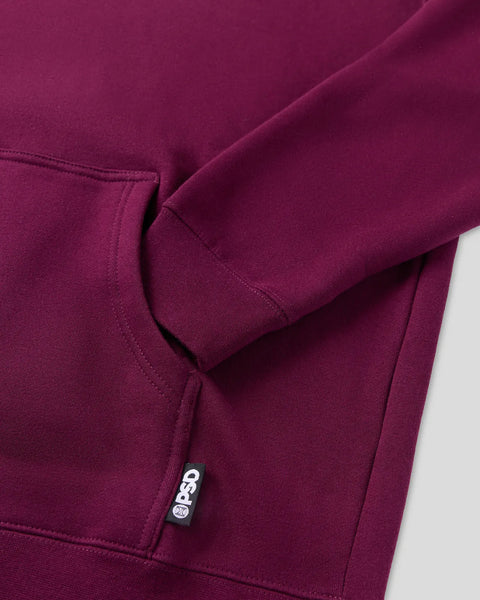 Maroon pullover hoodie with ribbed cuffs and sleeve seams visible, showing fabric texture and PSD brand label.