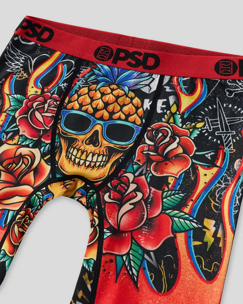 Black briefs with colorful tattoo-style graphics including a skull with pineapple hair, roses, and rainbow accents; red waist