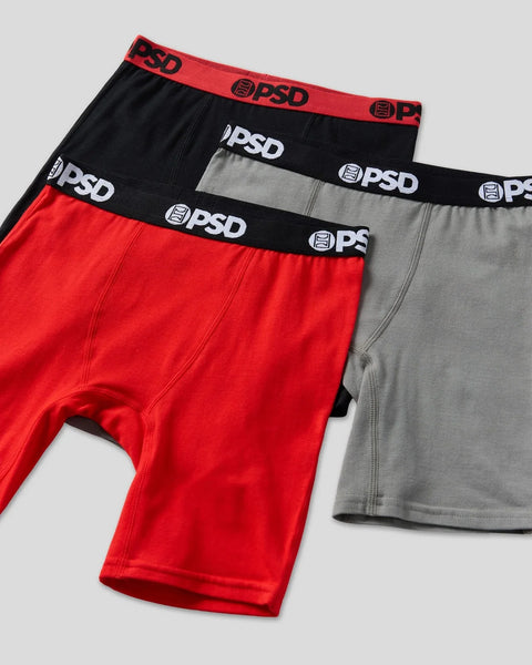 Three PSD boxer briefs in red, black, and gray with branded elastic waistbands.