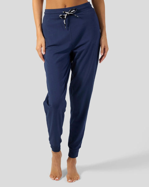 Navy blue joggers with drawstring waist and tapered cuffs on model.