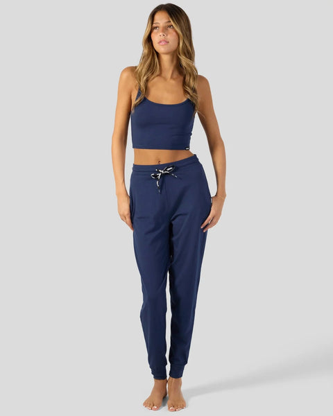 Dark blue joggers with drawstring waist and matching cropped tank top on model.