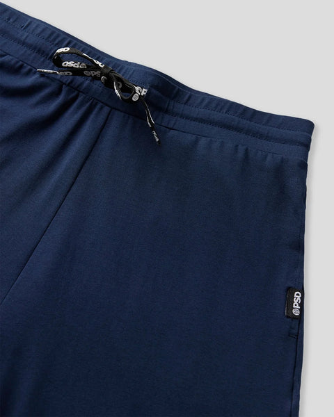 Dark blue joggers with drawstring waist and brand label visible on the hip.