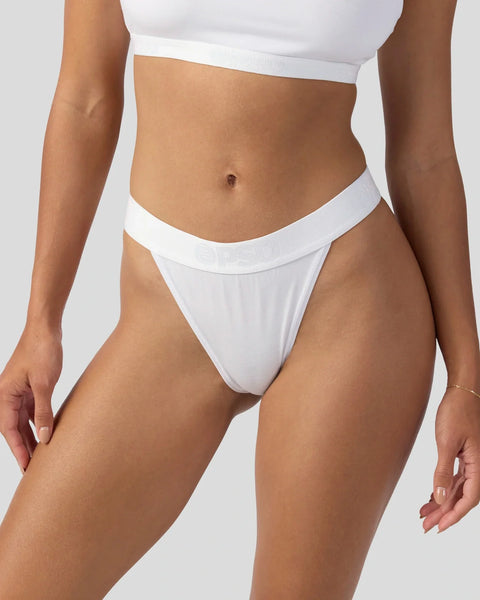White modal crop top and bikini bottom displayed on model against neutral background.