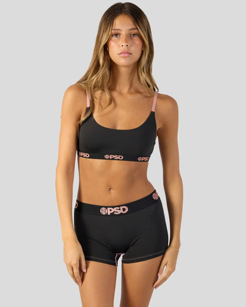Black sports bra and shorts set with pink straps and PSD branding on waistbands.