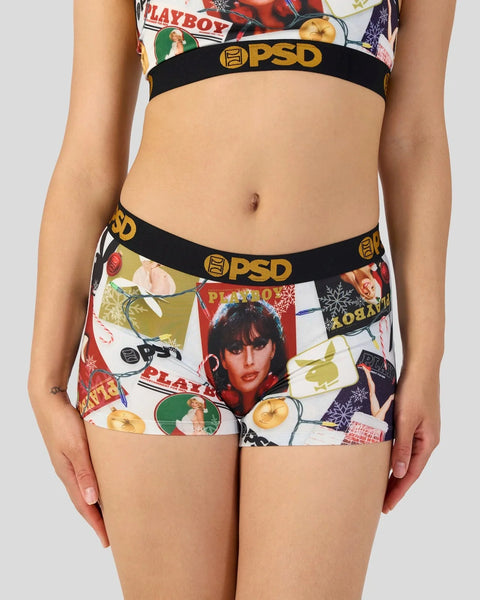 Playboy-print boy shorts with black waistband featuring PSD branding and holiday-themed collage graphics.