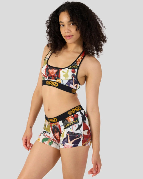 Woman wearing Playboy-branded bra and shorts set with multicolored vintage magazine cover print and black elastic waistband.
