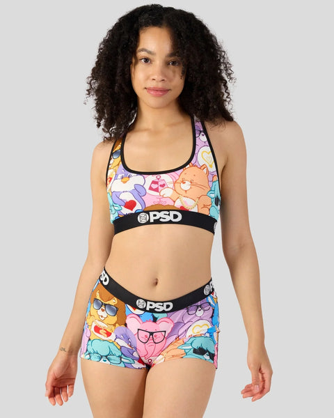 Woman wearing colorful Care Bears-patterned sports bra and shorts with black PSD waistbands.