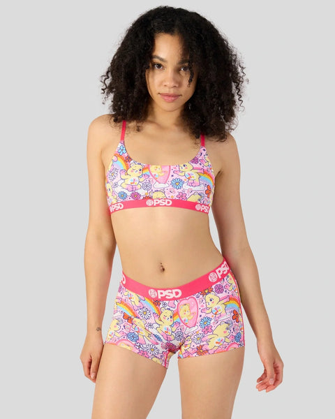 Woman wearing pink Care Bears-patterned bra and shorts set with red straps and PSD waistband.