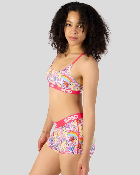Woman wearing pink Care Bears printed halter bikini top and matching shorts with rainbow and character graphics.