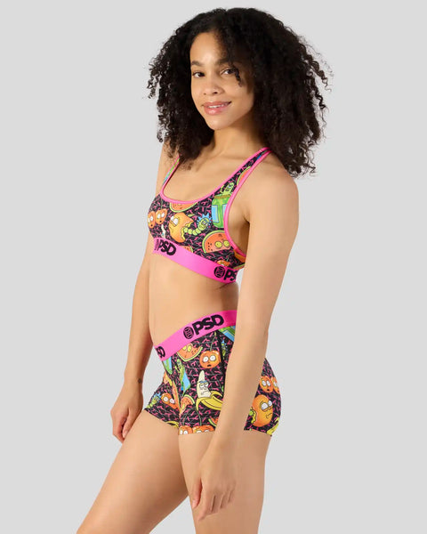 Woman wearing a pink and multicolor Rick and Morty printed sports bra and matching shorts set.