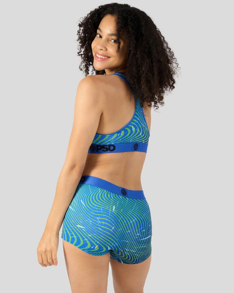 Woman wearing blue and lime green striped sports bra and shorts set with swirl pattern design.