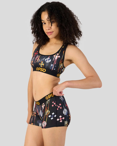 Black sports bra and shorts set with multicolored graphic print and brand logos throughout.