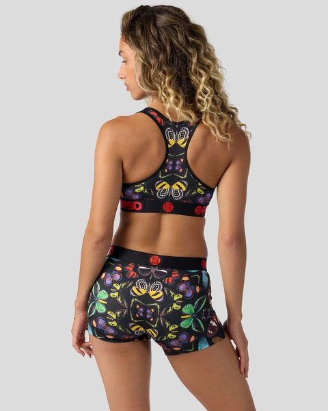 Black sports bra and shorts set with colorful butterfly and insect print pattern throughout.