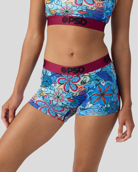 Colorful floral print sports bra and shorts set with burgundy trim and branding.