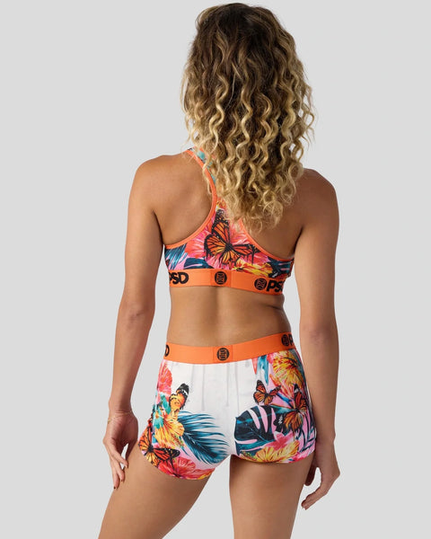 Woman wearing colorful tropical floral bikini with orange trim and butterfly print, shown from back.