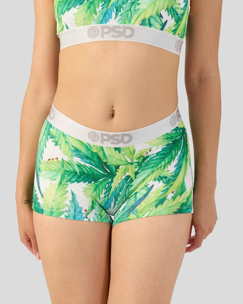 Woman wearing green and white leaf-print crop top and matching shorts with white elastic waistbands.