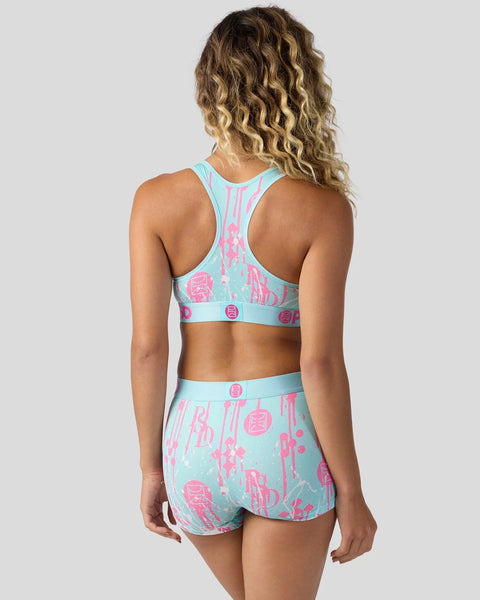 Woman wearing light blue sports bra and matching shorts with pink graphic print, shown from behind.