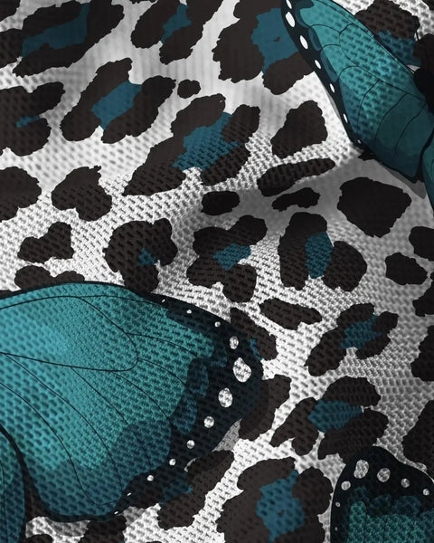 Mesh fabric with teal butterfly wings and black leopard spots on white background.
